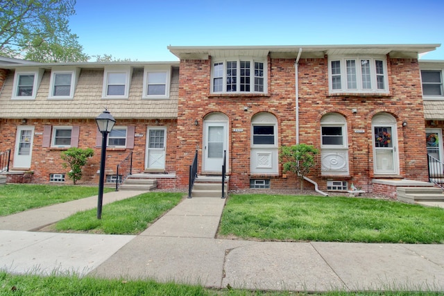2611 Kingstowne Dr, Michigan, MI 48390 - townhome / multi-family property featuring a front yard, entry steps, and brick siding