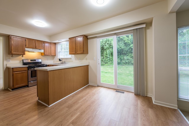 3048 Turnberry Ln, Ann Arbor, MI 48108 - kitchen featuring stainless steel range with gas cooktop, under cabinet range hood, light wood-type flooring, light countertops, and a peninsula
