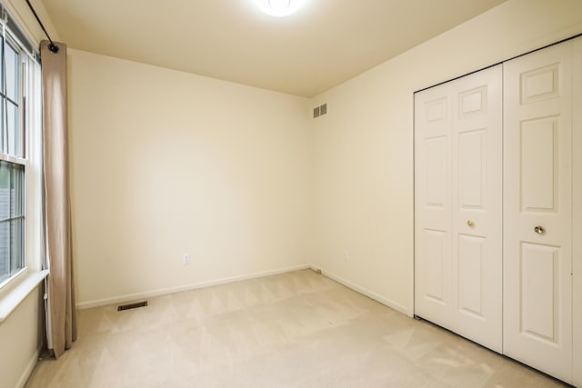 3048 Turnberry Ln, Ann Arbor, MI 48108 - unfurnished bedroom featuring light carpet, baseboards, multiple windows, and a closet