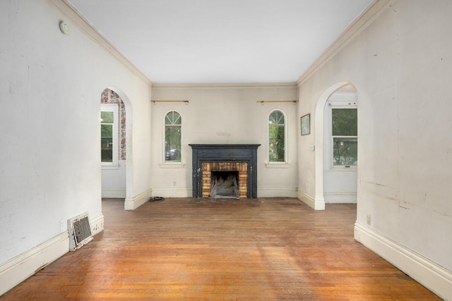554 Ethel Ave SE, Grand Rapids, MI 49506 - unfurnished living room featuring ornamental molding, a fireplace, wood finished floors, arched walkways, and baseboards