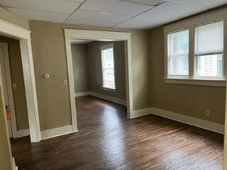 872 Mcalister Ave, Benton Harbor, MI 49022 - empty room featuring baseboards, dark wood-type flooring, and a drop ceiling