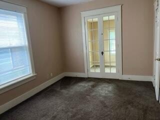 872 Mcalister Ave, Benton Harbor, MI 49022 - spare room with baseboards, french doors, and dark colored carpet