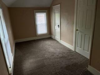 872 Mcalister Ave, Benton Harbor, MI 49022 - unfurnished bedroom with lofted ceiling, carpet, and baseboards