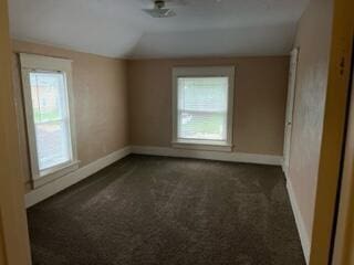 872 Mcalister Ave, Benton Harbor, MI 49022 - empty room with healthy amount of natural light, dark carpet, baseboards, and lofted ceiling
