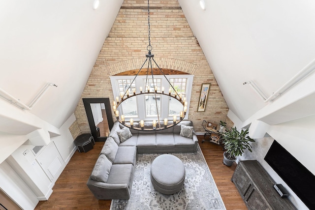 810 Cottageview Dr, Traverse City, MI 49684 - living room with wood finished floors, high vaulted ceiling, brick wall, and a chandelier