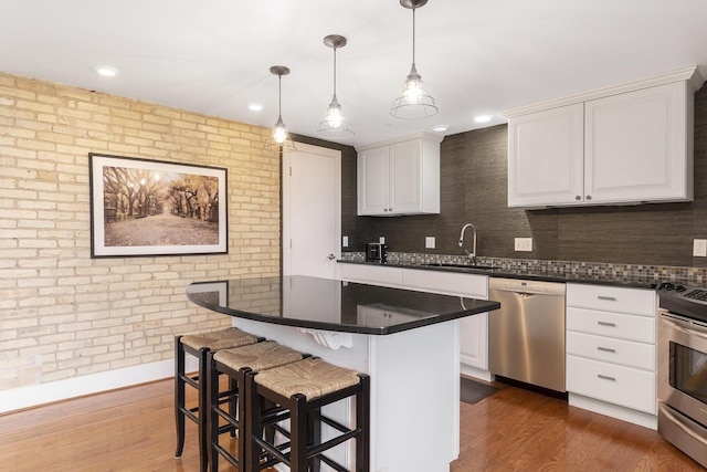 810 Cottageview Dr, Traverse City, MI 49684 - kitchen with stainless steel appliances, a sink, backsplash, white cabinetry, and recessed lighting
