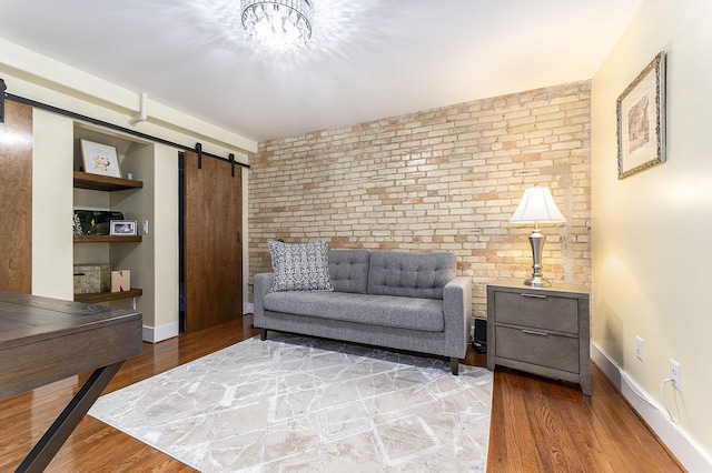 810 Cottageview Dr, Traverse City, MI 49684 - living area featuring a barn door, brick wall, light wood-type flooring, and baseboards