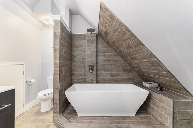 810 Cottageview Dr, Traverse City, MI 49684 - full bath featuring a freestanding bath, lofted ceiling, toilet, and vanity