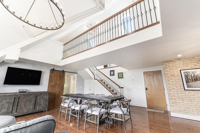 810 Cottageview Dr, Traverse City, MI 49684 - dining room with a barn door, a towering ceiling, wood finished floors, stairs, and baseboards