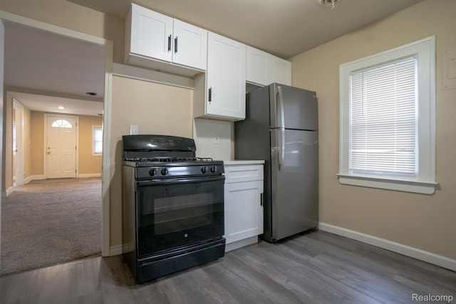 26640 Pattow St, Roseville, MI 48066 - kitchen with black gas stove, freestanding refrigerator, baseboards, and white cabinetry