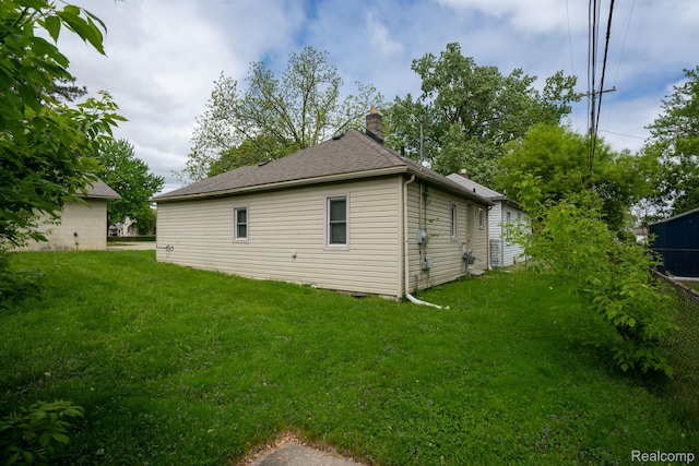 26640 Pattow St, Roseville, MI 48066 - view of side of property featuring a chimney, a yard, and roof with shingles