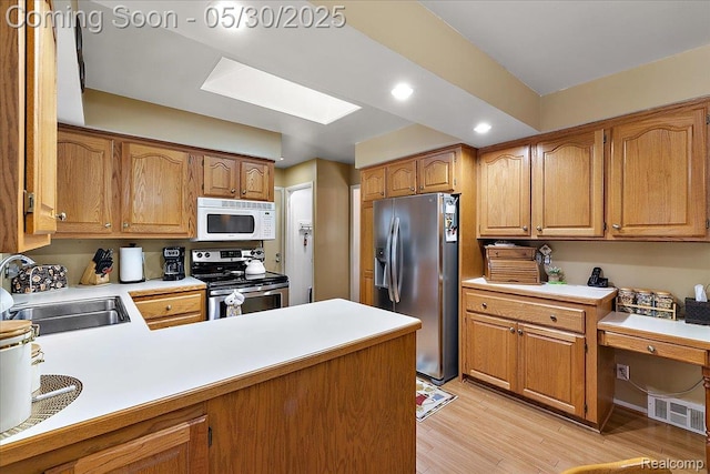 7188 Vicksburg Cir, Shelby Twp, MI 48317 - kitchen featuring stainless steel appliances, a sink, light countertops, light wood-type flooring, and a skylight