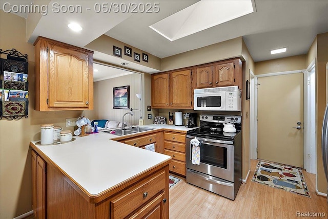 7188 Vicksburg Cir, Shelby Twp, MI 48317 - kitchen featuring white microwave, electric range, a sink, light countertops, and light wood-style flooring