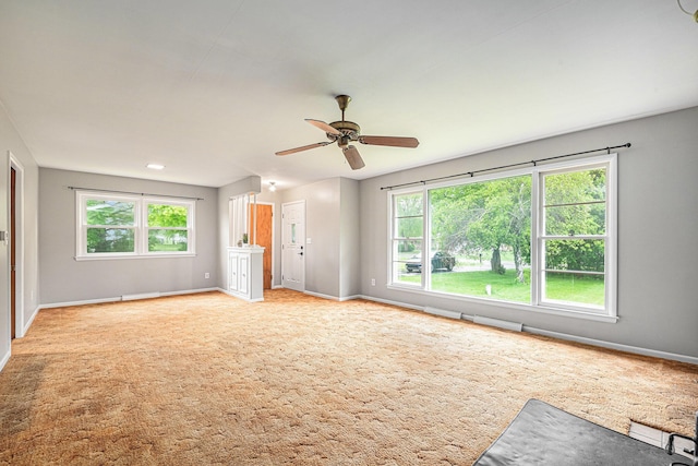 7432 Burlingame Ave SW, Byron Center, MI 49315 - unfurnished living room with plenty of natural light, baseboards, and a ceiling fan