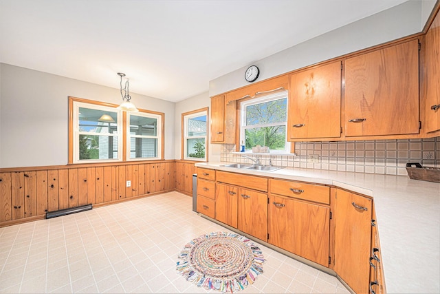 7432 Burlingame Ave SW, Byron Center, MI 49315 - kitchen featuring a sink, light countertops, a wainscoted wall, decorative backsplash, and wooden walls