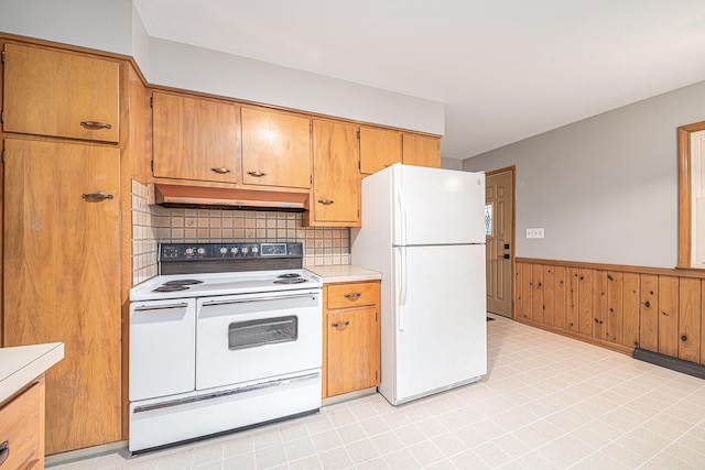 7432 Burlingame Ave SW, Byron Center, MI 49315 - kitchen featuring white appliances, under cabinet range hood, light countertops, wainscoting, and tasteful backsplash