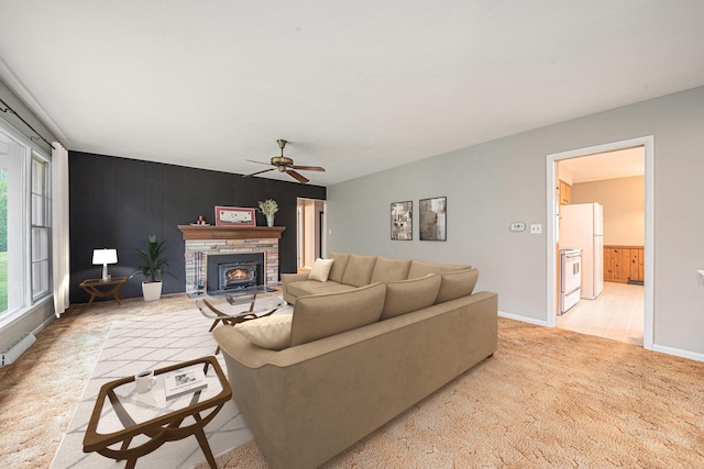 7432 Burlingame Ave SW, Byron Center, MI 49315 - living room with plenty of natural light, light colored carpet, a ceiling fan, and a warm lit fireplace