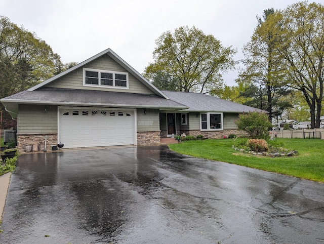 6919 Abrahamson Rd, Ludington, MI 49431 - view of front of house with stone siding, asphalt driveway, a shingled roof, and a garage