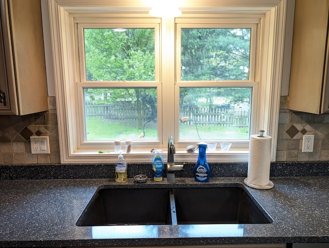 6919 Abrahamson Rd, Ludington, MI 49431 - kitchen with a sink, healthy amount of natural light, decorative backsplash, and dark stone countertops