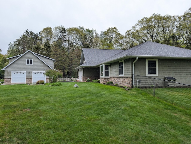 6919 Abrahamson Rd, Ludington, MI 49431 - view of side of home featuring a garage, stone siding, and roof with shingles