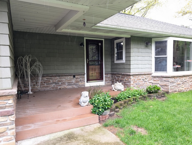 6919 Abrahamson Rd, Ludington, MI 49431 - property entrance featuring roof with shingles, stone siding, and a porch