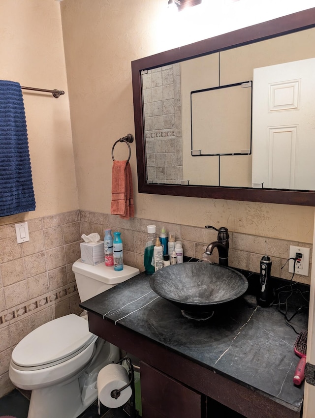 6919 Abrahamson Rd, Ludington, MI 49431 - bathroom with toilet, vanity, wainscoting, and tile walls