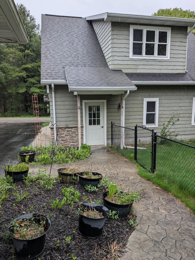 6919 Abrahamson Rd, Ludington, MI 49431 - view of front of property featuring a shingled roof and stone siding