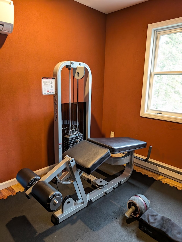 6919 Abrahamson Rd, Ludington, MI 49431 - exercise room with a baseboard radiator, baseboards, and an AC wall unit