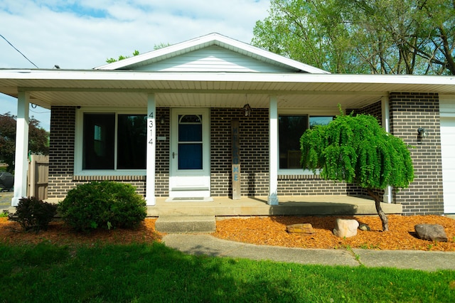 4314 Wilson Ave SW, Grandville, MI 49418 - view of front of house with brick siding, covered porch, and a garage