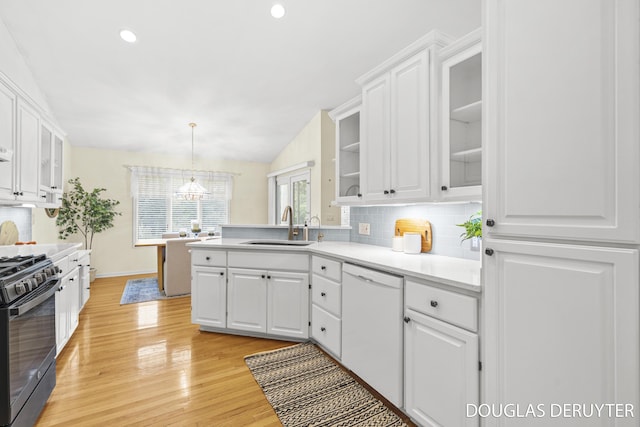 7470 Parmalee Rd, Middleville, MI 49333 - kitchen featuring white dishwasher, a sink, black gas stove, white cabinetry, and decorative backsplash
