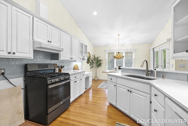 7470 Parmalee Rd, Middleville, MI 49333 - kitchen with gas range, under cabinet range hood, a sink, dishwasher, and white cabinetry