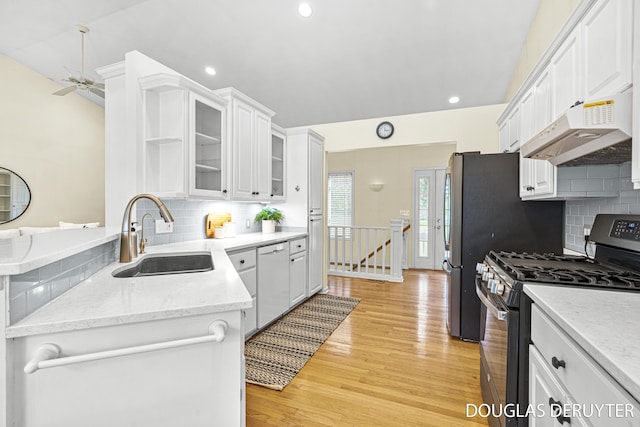 7470 Parmalee Rd, Middleville, MI 49333 - kitchen with gas stove, under cabinet range hood, a sink, dishwasher, and white cabinets