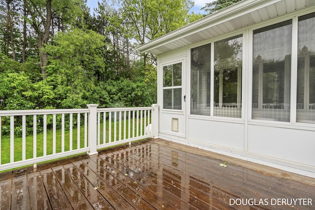 7470 Parmalee Rd, Middleville, MI 49333 - wooden deck with a sunroom, view of wooded area, and a lawn