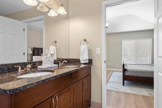4139 Persimmon Dr, Ypsilanti, MI 48197 - bathroom with wood finished floors, double vanity, baseboards, connected bathroom, and a chandelier