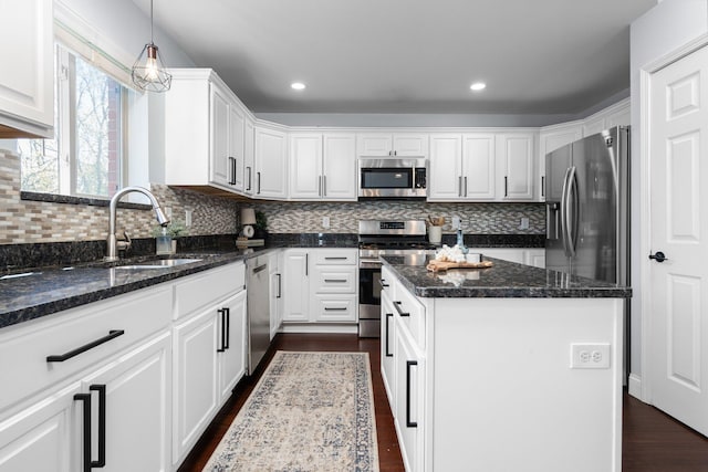 4139 Persimmon Dr, Ypsilanti, MI 48197 - kitchen featuring stainless steel appliances, a sink, white cabinets, a kitchen island, and dark wood-type flooring