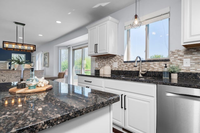4139 Persimmon Dr, Ypsilanti, MI 48197 - kitchen with stainless steel dishwasher, a sink, tasteful backsplash, white cabinetry, and decorative light fixtures