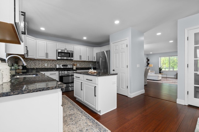 4139 Persimmon Dr, Ypsilanti, MI 48197 - kitchen featuring appliances with stainless steel finishes, a sink, backsplash, white cabinets, and dark wood-type flooring
