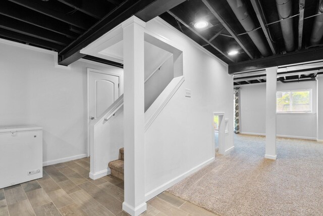 4139 Persimmon Dr, Ypsilanti, MI 48197 - basement with white refrigerator, baseboards, stairway, and wood finished floors