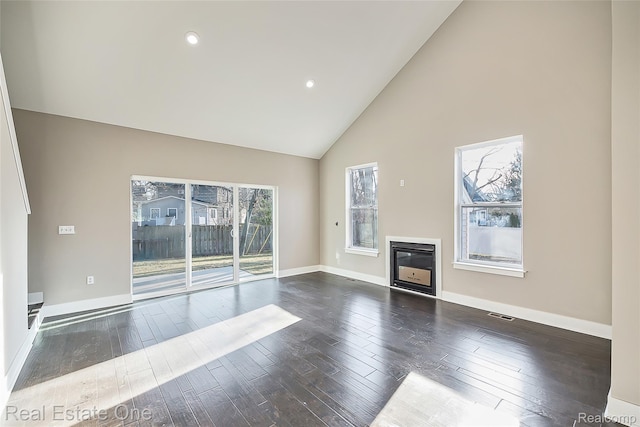 527 Indian Oaks Dr, Howell, MI 48843 - unfurnished living room with hardwood / wood-style floors, high vaulted ceiling, a glass covered fireplace, baseboards, and recessed lighting