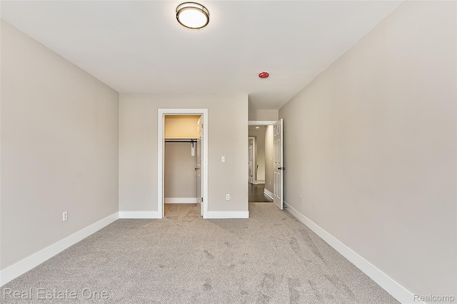 527 Indian Oaks Dr, Howell, MI 48843 - unfurnished bedroom with a spacious closet, light colored carpet, baseboards, and a closet