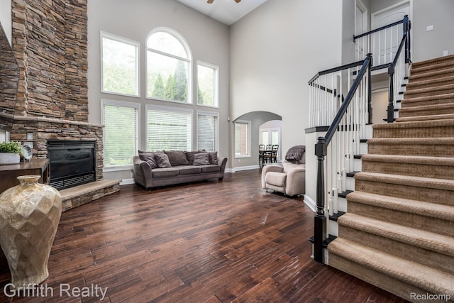 1804 Morgan Lake Ct, Brighton, MI 48114 - living area with arched walkways, a towering ceiling, stairway, hardwood / wood-style flooring, and a fireplace