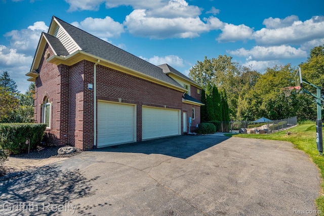 1804 Morgan Lake Ct, Brighton, MI 48114 - view of side of property with brick siding, asphalt driveway, a shingled roof, and a garage