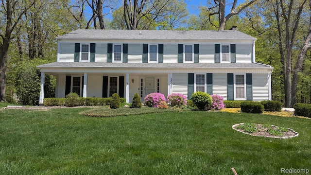 28532 Perryville Way, Farmington Hills, MI 48331 - colonial-style house featuring a front yard, a chimney, a porch, and a shingled roof