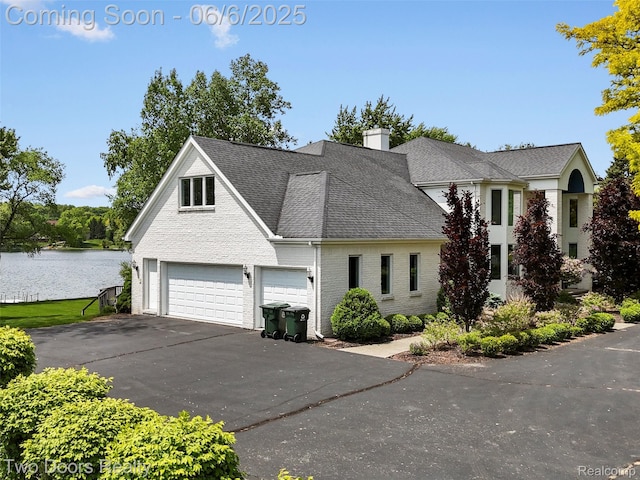 532 Shrewsbury Dr, Clarkston, MI 48348 - traditional-style home with roof with shingles, asphalt driveway, a garage, brick siding, and a water view