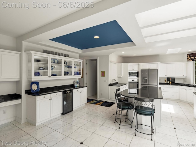 532 Shrewsbury Dr, Clarkston, MI 48348 - kitchen featuring appliances with stainless steel finishes, wine cooler, a sink, a skylight, and dark countertops