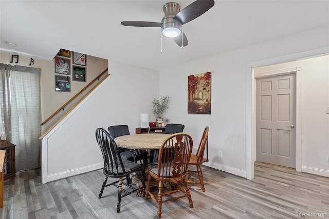 13902 Toepfer Rd, Warren, MI 48089 - dining area featuring light wood-style flooring, baseboards, stairway, and a ceiling fan