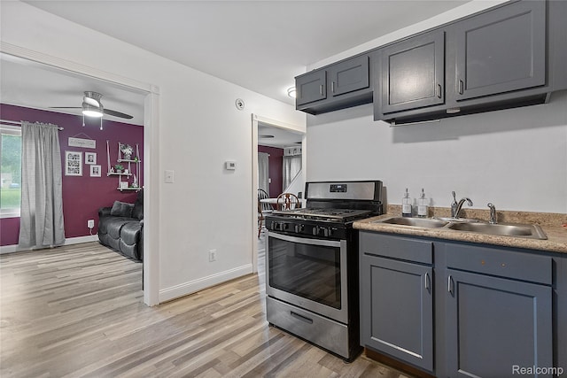 13902 Toepfer Rd, Warren, MI 48089 - kitchen featuring gas range, a sink, light wood-style floors, baseboards, and a ceiling fan
