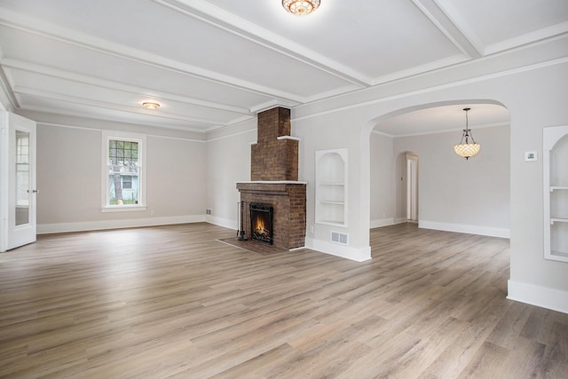 40 Eldredge St, Battle Creek, MI 49037 - unfurnished living room featuring light wood-style flooring, beam ceiling, baseboards, a brick fireplace, and crown molding