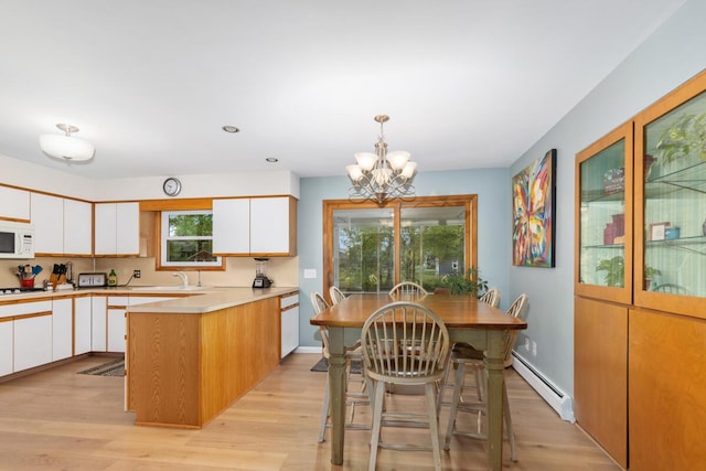 2294 Pinewood St, Jenison, MI 49428 - kitchen with baseboard heating, white microwave, a sink, white cabinetry, and recessed lighting