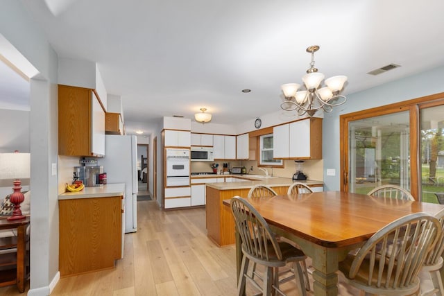 2294 Pinewood St, Jenison, MI 49428 - dining room with a chandelier and light wood-style flooring